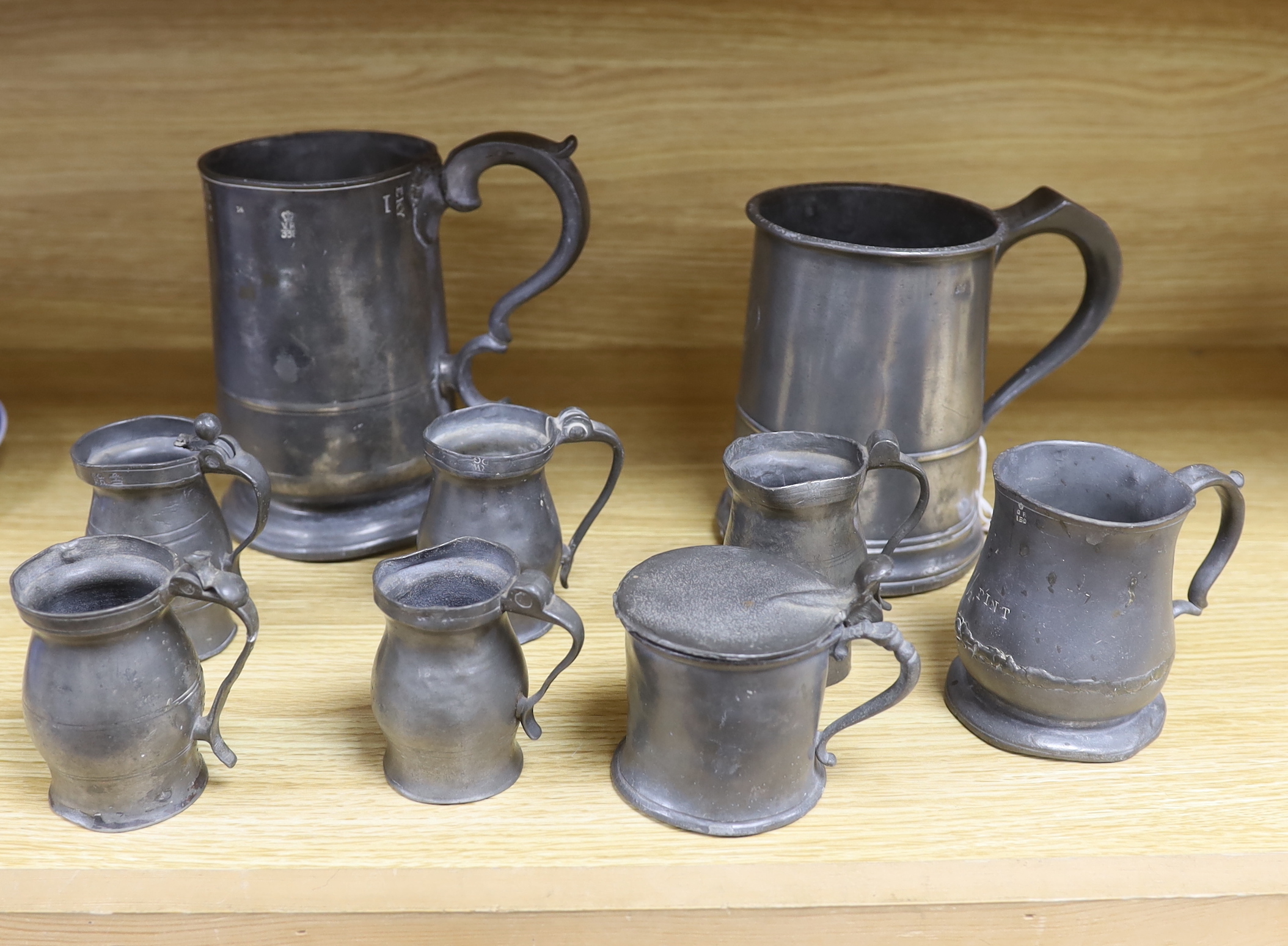 A collection of 19th century pewter ale mugs pewter measures and a mustard pot tallest 16.5 cm high